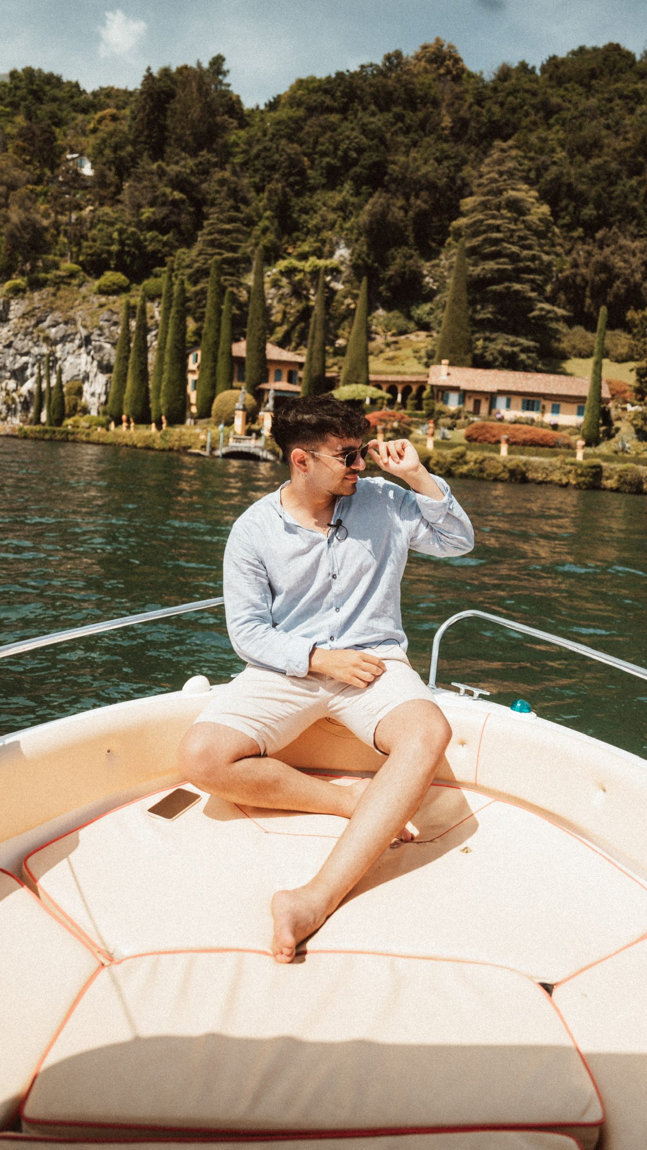 Matteo Spera seduto sulla prua di una barca su un lago