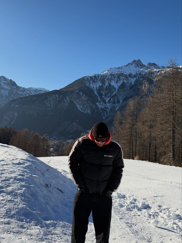 Matteo Spera sulla neve con le montagne alle spalle